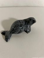 Right side view of dark grey soapstone seal carving