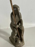 Full view of stone carving showing figure, spear, and animal