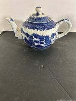 Side view of blue and white ceramic teapot showing pattern and shape