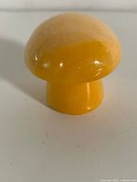Yellow-orange carved stone mushroom figurine front view