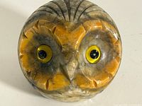 Front view showing owl face, glass eyes, yellow and gray alabaster