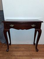 Front view of mahogany console table showing drawer and cabriole legs