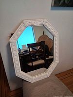 Front view of octagonal mirror with white decorative frame