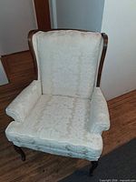 Front view of upholstered wingback armchair