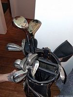 Top view of clubs inside bag showing woods, irons and putter