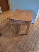 Full view of side table showing top, drawer front and legs