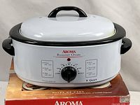 Front view of Aroma 8-quart roaster oven on original box showing control panel and branding