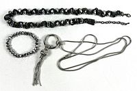 Group shot of bead necklace, stretch bracelet, and chain tassel necklace