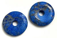 Two blue lapis lazuli donut discs on white background showing size and color variation