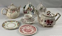 Entire lot showing two teapots, three cup-saucer sets, two plates
