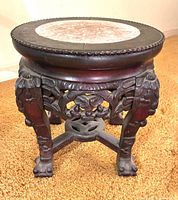 Front and side view of carved wooden stand showing carvings and overall form