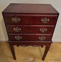 Front view showing three drawers with brass-finish pulls