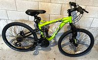 Full left-side view of Schwinn green dual-suspension mountain bike