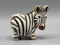Front three-quarter view of zebra figurine showing face, stripes, glaze details