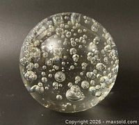 Front view of clear glass paperweight showing controlled bubbles