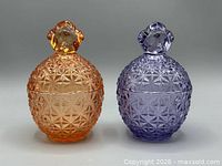 Lavender and peach pressed glass storage pots with lids, front view