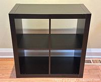 Front view of black brown four-cube IKEA Kallax shelving unit