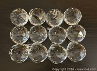 Twelve clear faceted glass ball pendants arranged in rows