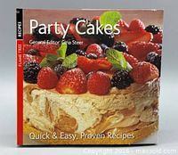 Front cover of hardcover cookbook showing title, author, and cake photo