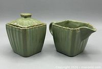 Front view of creamer and sugar bowl with lid