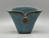 Front view of blue crackle ceramic fan vase with seashell accent