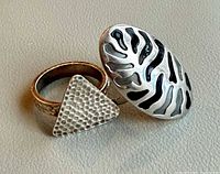 Both rings—oval zebra design and triangular hammered design—side by side