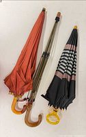 Two folded umbrellas side by side showing handles and canopies