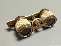 Angled view of brass opera glasses showing barrels and handle