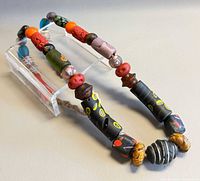 Necklace laid on surface showing variety of beads and cord