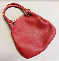 Front view of red Plinio Visona leather tote showing overall shape, pebbled texture and handles
