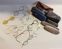 Group shot of nine eyeglasses and six cases