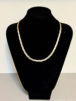 Necklace displayed on black bust showing overall length and style