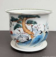 Front view showing crane and pine motif on planter with saucer