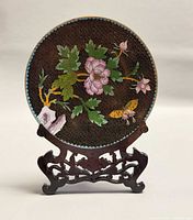 Front view of cloisonné plate on stand, showing floral motif