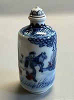 Front view of blue and white porcelain snuff bottle showing painted man and horse