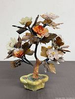 Front view of carved stone floral bonsai showing multicolour blossoms and stone pot