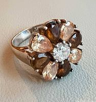 Oblique view of ring showing cluster of pear-cut stones and center clear stone