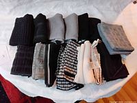 Row of folded black and grey dish towels, waffle and terry textures on white surface