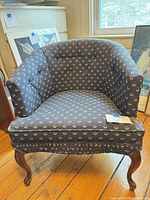 Front and side view of navy tulip upholstered accent chair showing full form, legs, and upholstery
