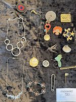 Full layout of approx. 15 costume jewelry pieces on black fabric