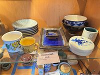 All ceramics on glass shelf showing variety of pieces