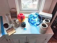 Group shot of all items on cabinet under window