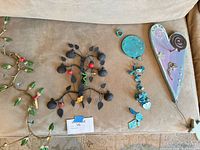 Group layout showing metal bird rack, apple-tree hanging, turquoise bead ornament, wooden heart plaque