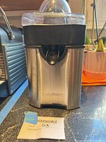 Front view of Cuisinart stainless-steel citrus juicer with transparent dome lid and spout