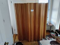 Screen fully opened showing eight curved plywood panels