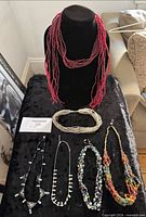 Front view of all visible necklaces on black display and cloth