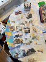 Overview of multiple zip-top bags, small tin and boxes containing assorted beads on table