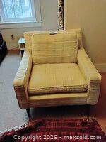 Front view of cream textured armchair with cushions and dark tapered legs