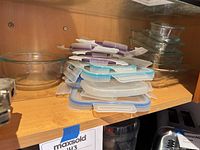 Stack of plastic lids next to round glass bowl; additional glass dishes visible