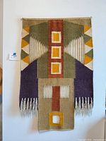 Full view of hanging tapestry showing overall design, colors, dimensions and fringe